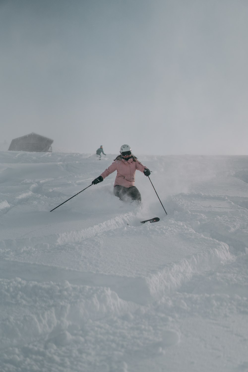 person in red jacket and black pants riding ski blades on snow covered ground during daytime