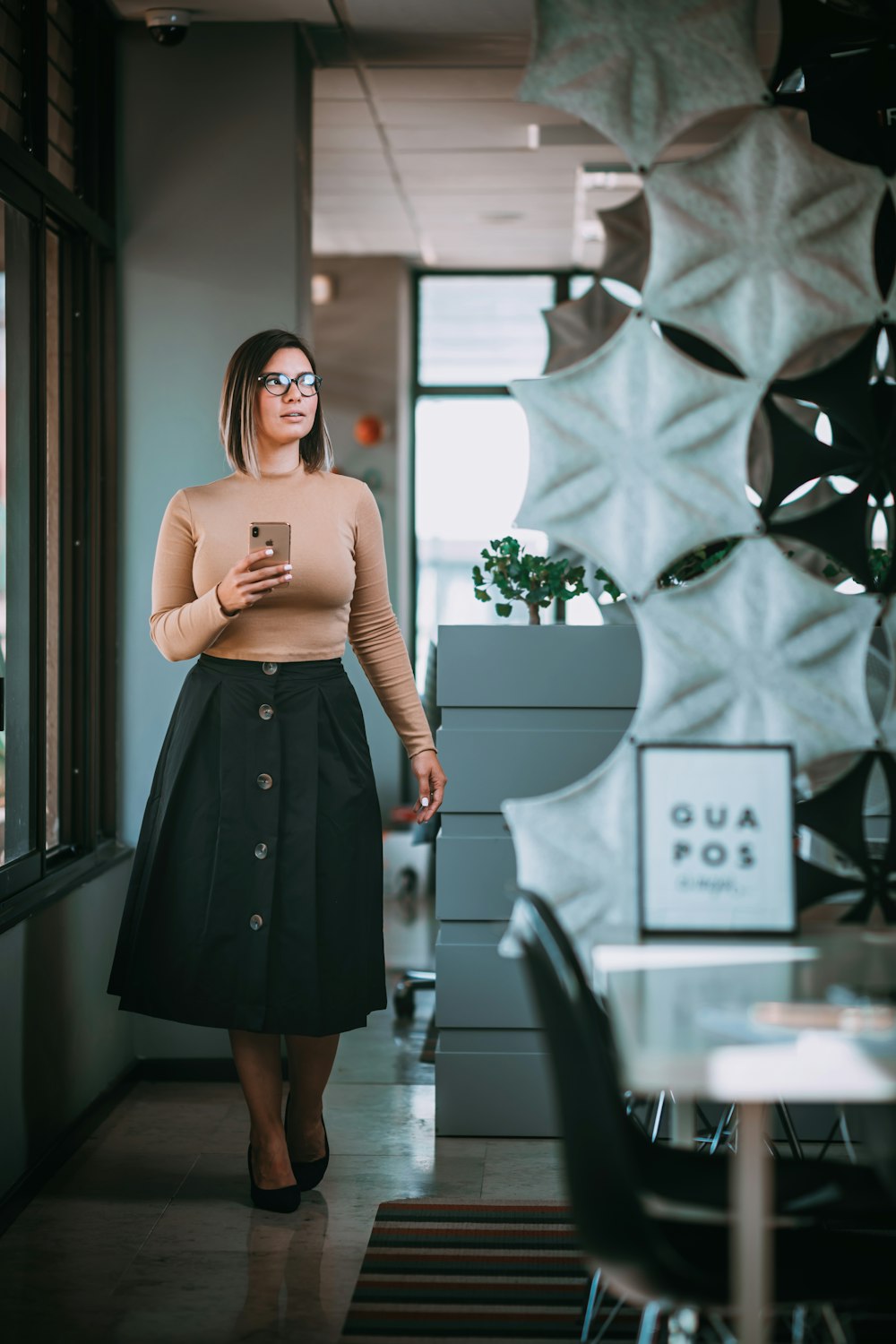 woman in black skirt standing near white and black wall