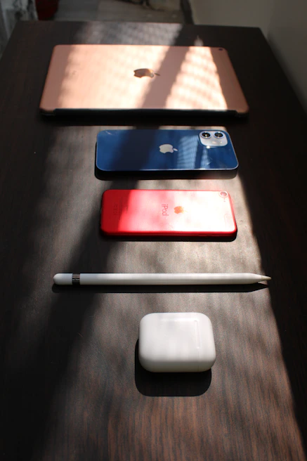 Modern electronic devices displayed on a sleek white surface with blue and violet lighting accents