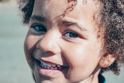 smiling woman with white and red flower on her ear