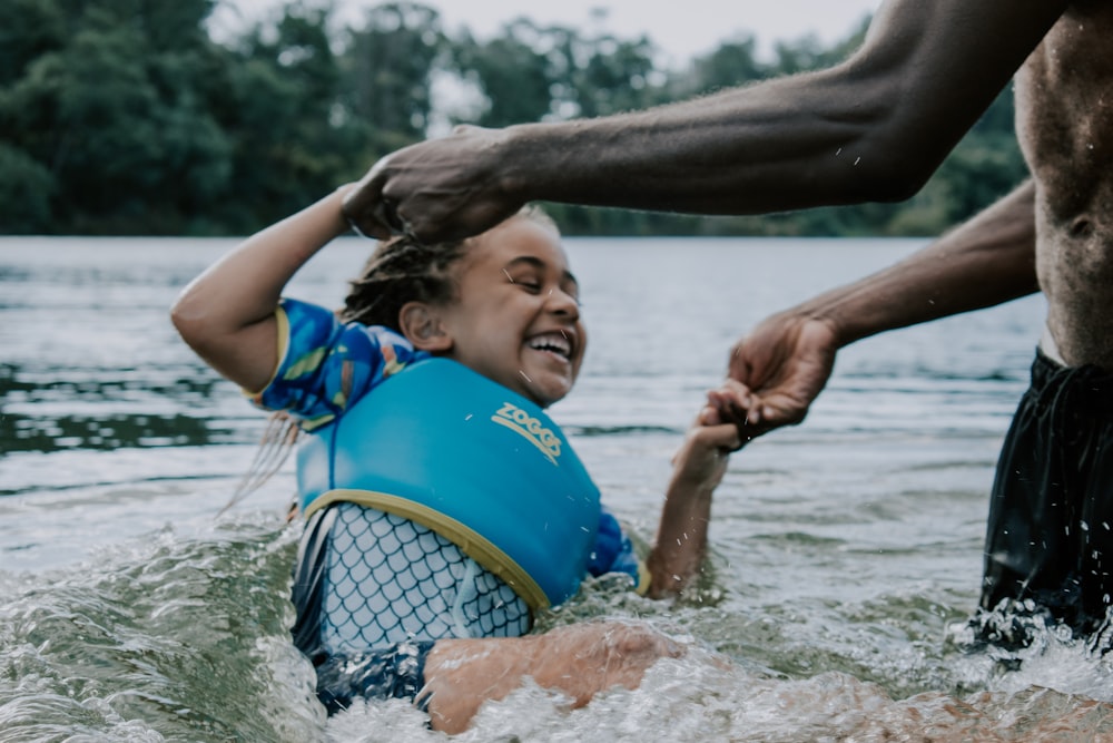 girl in blue and yellow tank top playing on water during daytime