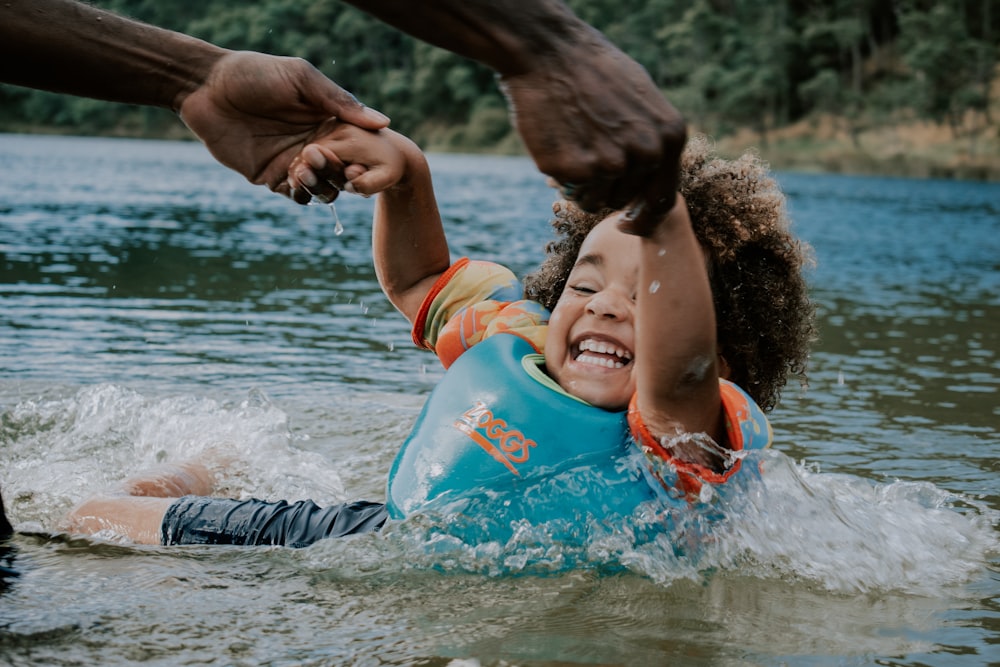 woman in orange and blue life vest on water