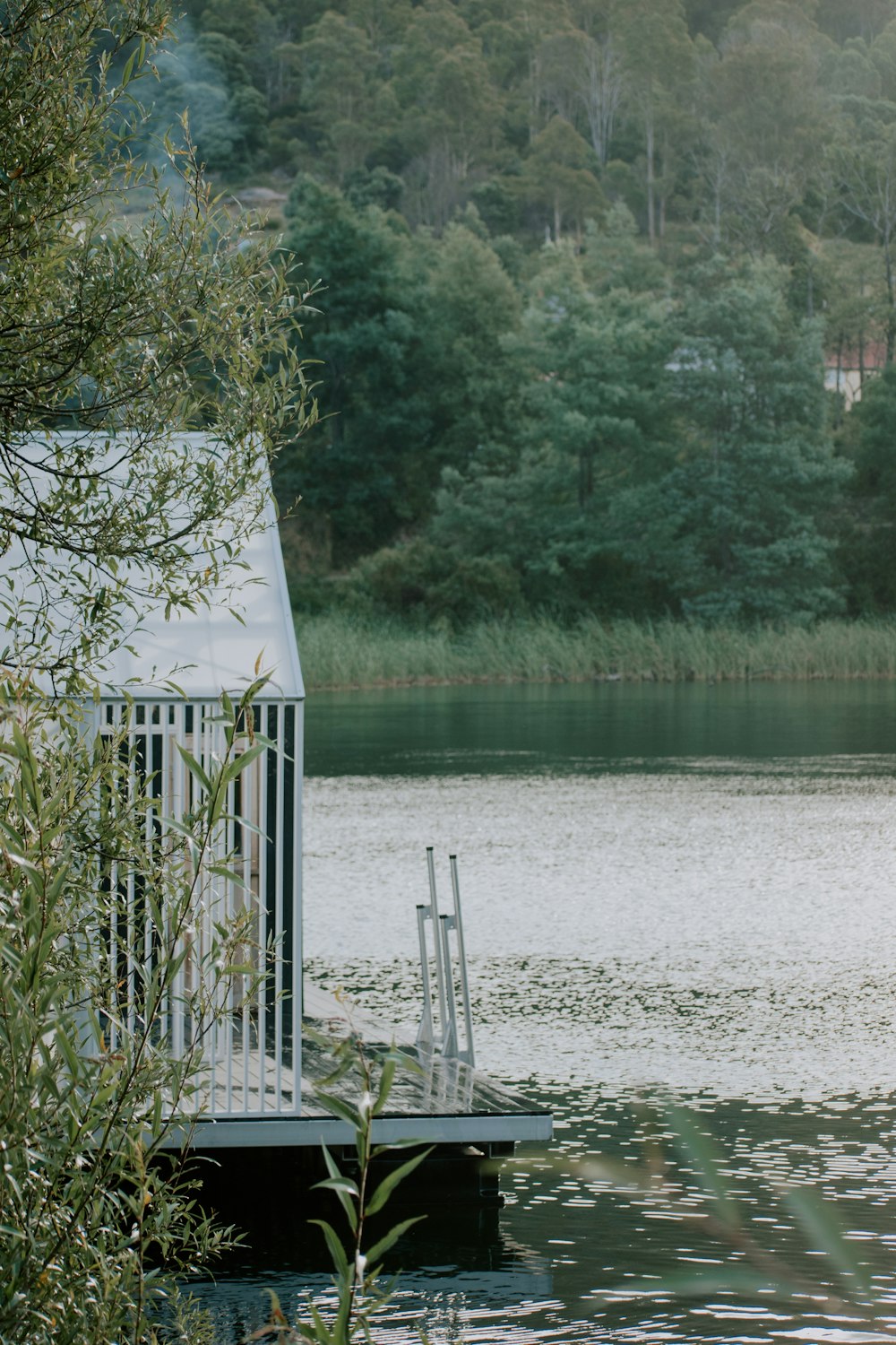 white wooden house near body of water during daytime