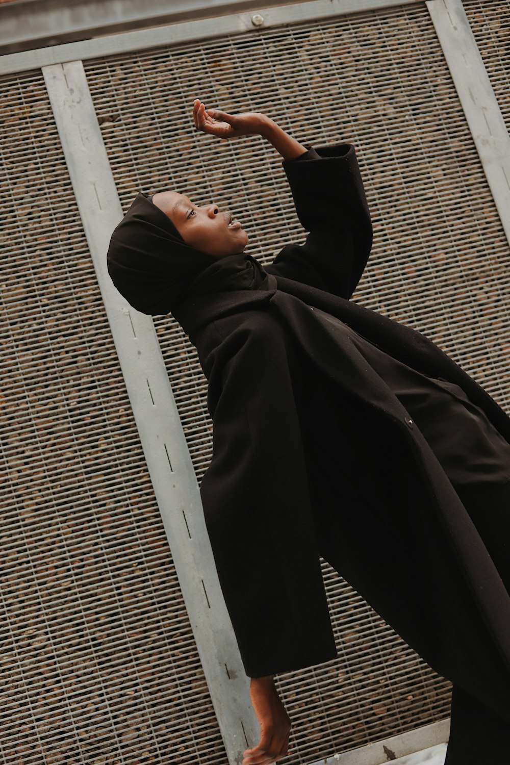 man in black robe lying on white metal bar