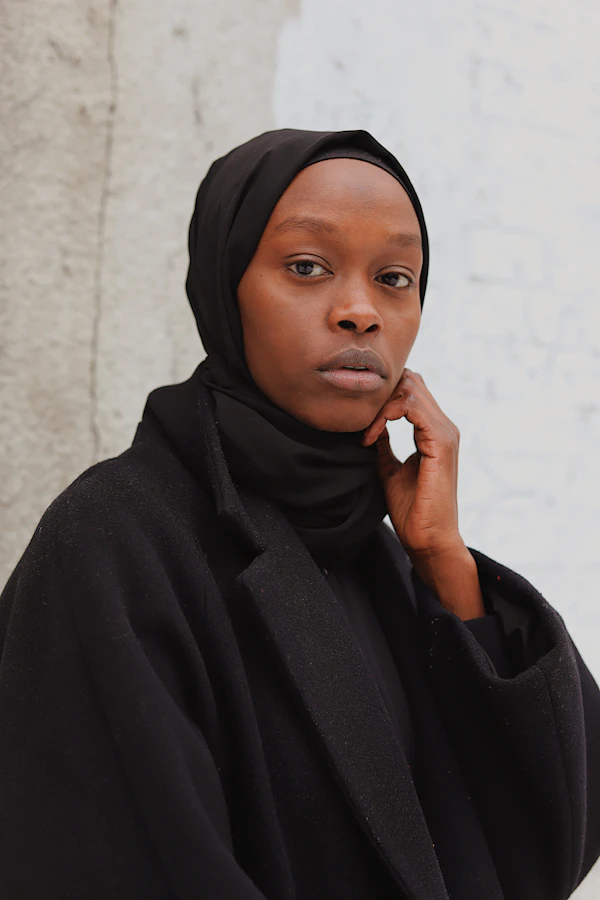 Portrait d'une femme en hijab et abaya noirs.