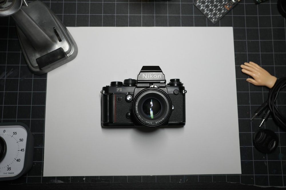 Appareil photo reflex numérique Nikon noir sur table blanche