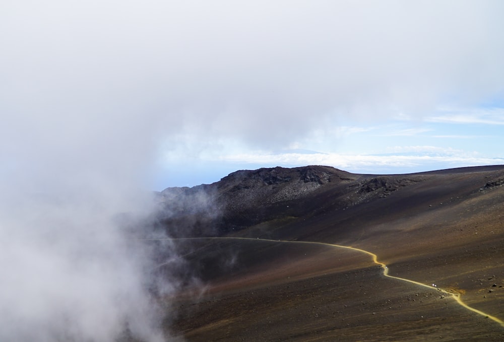 champ brun sous des nuages blancs