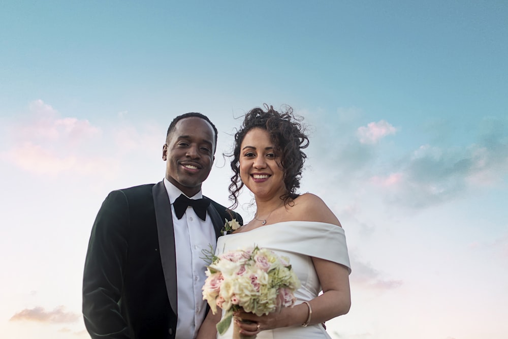 man in black suit and woman in white wedding dress