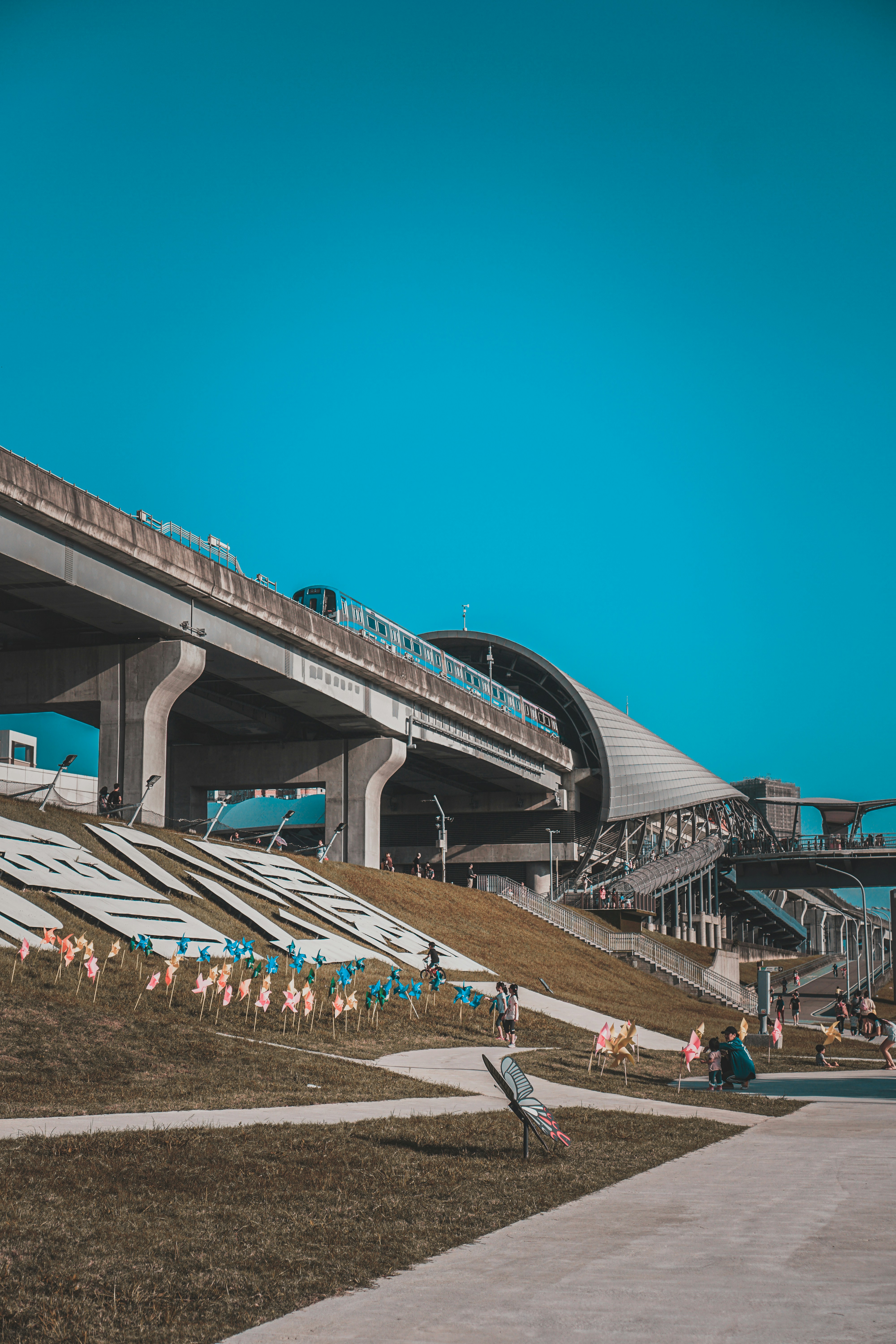 people walking on gray concrete bridge under blue sky during daytime