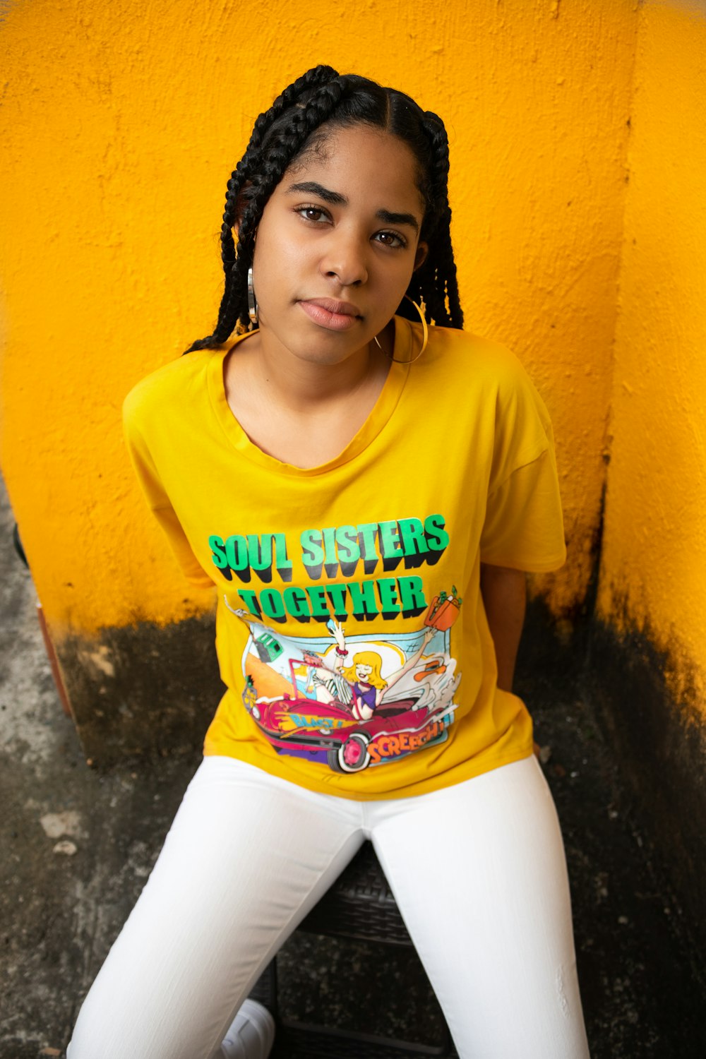 woman in yellow crew neck t-shirt and white pants sitting on white plastic seat