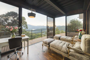 Inviting and comfortable hotel room with rustic decor and a large window overlooking nature.