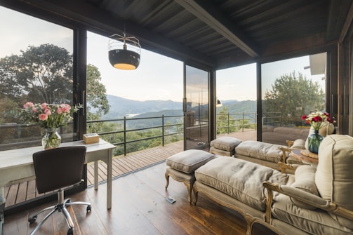 Elegant suite with seating area and large windows overlooking a scenic landscape.