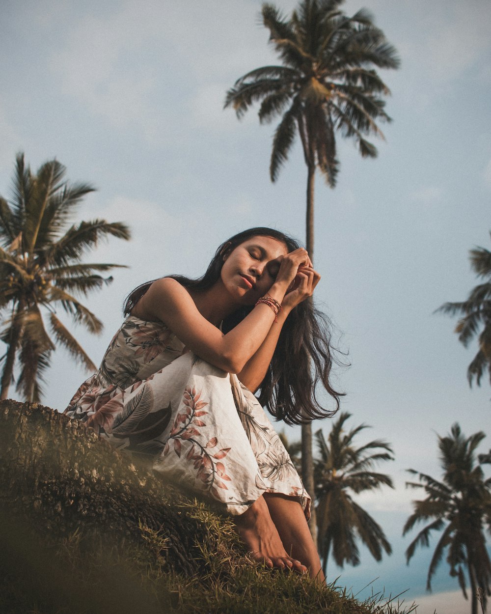 woman in white dress standing near palm tree during daytime