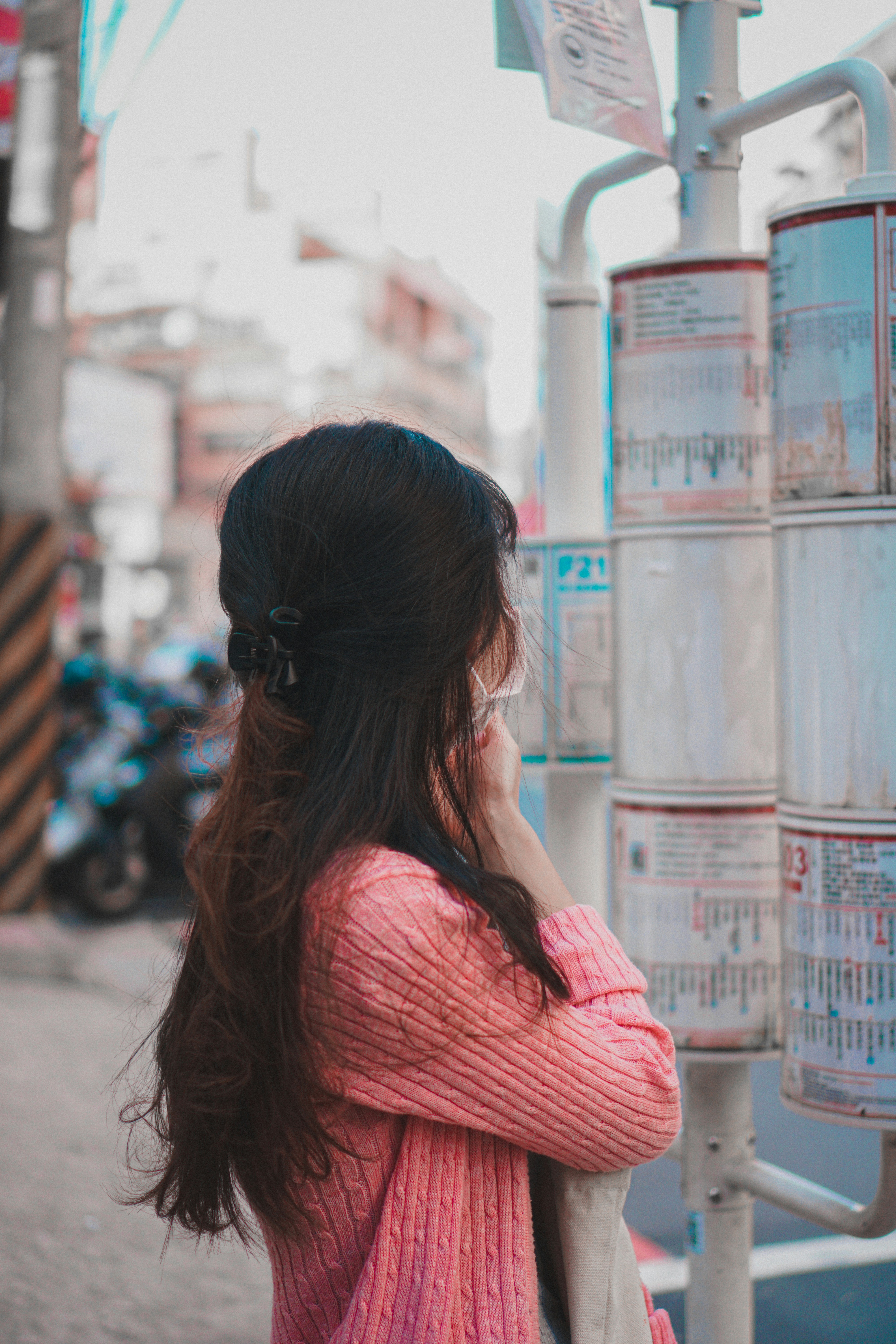 woman in pink shirt standing near building during daytime