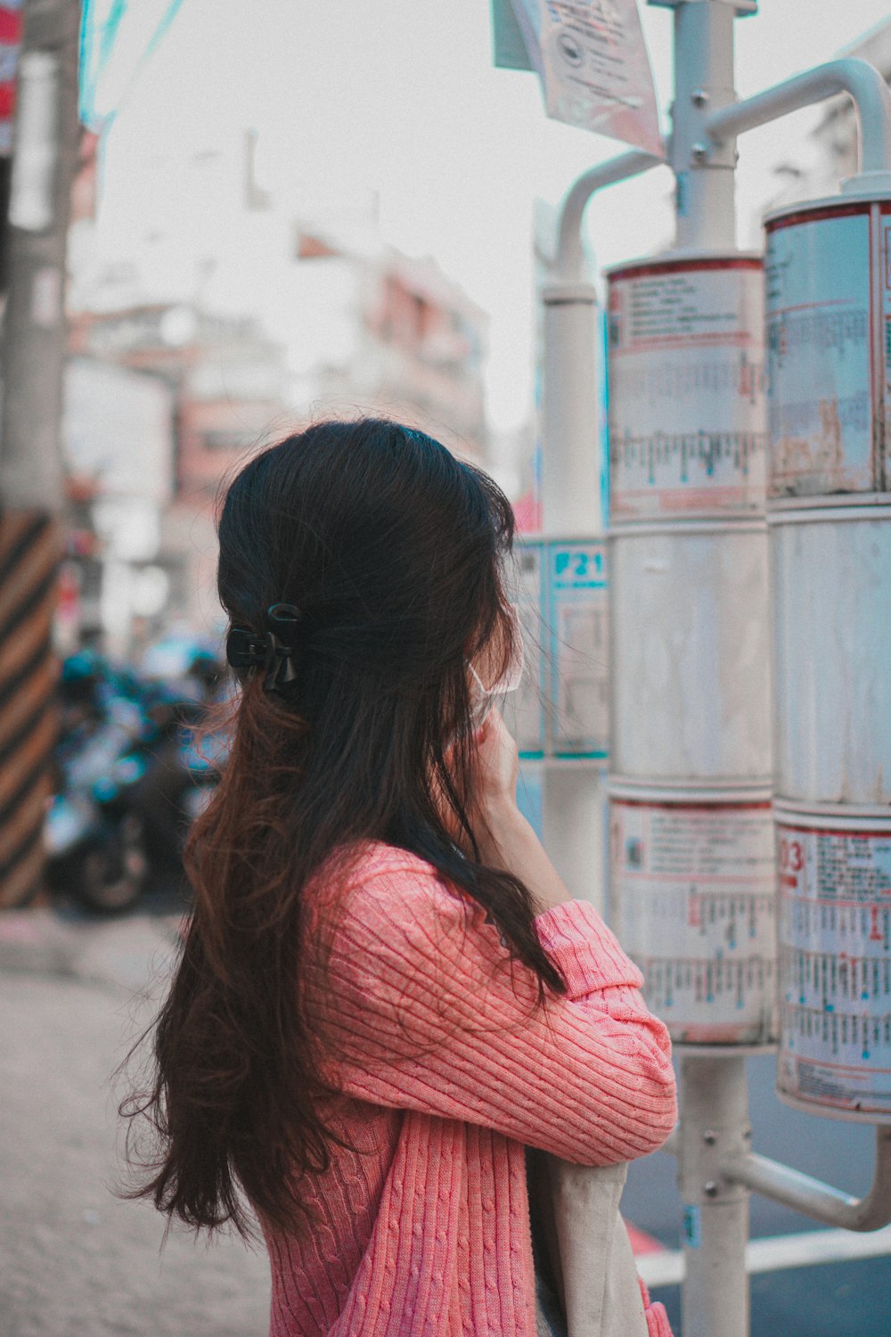 woman in pink shirt standing near building during daytime