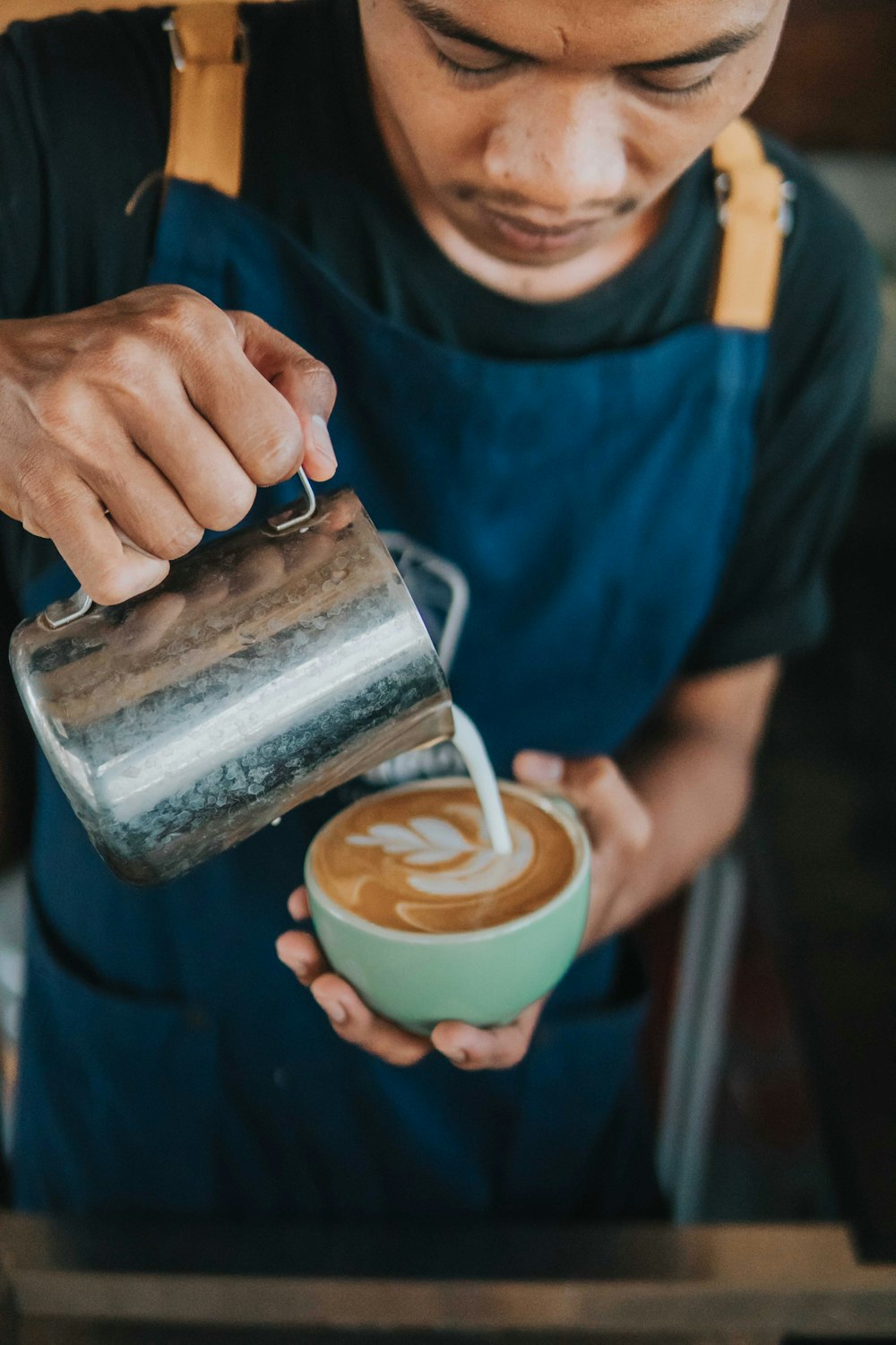 person pouring milk in white ceramic mug