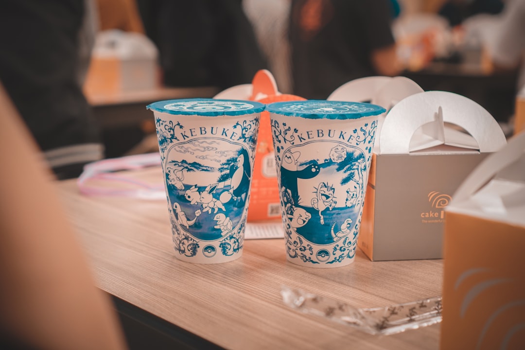 two white and blue floral cups on brown wooden table