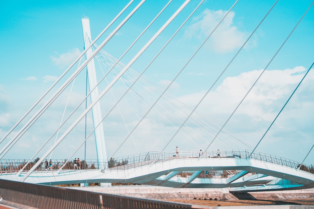 white and blue bridge under white clouds during daytime