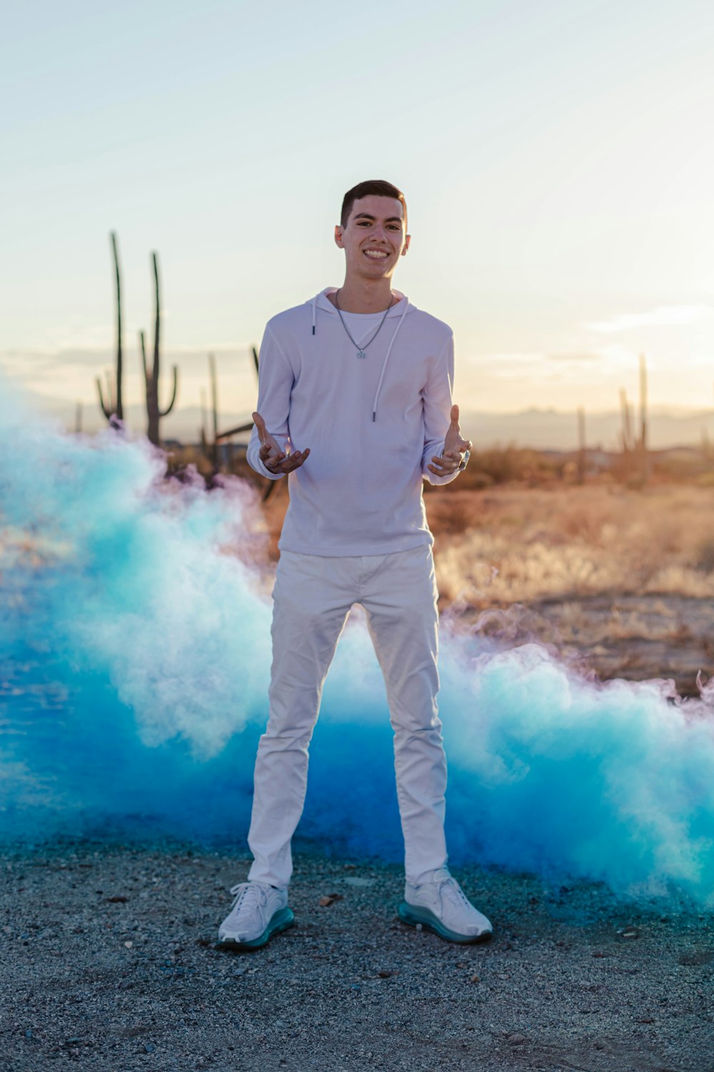 man in gray dress shirt and white pants standing on blue water