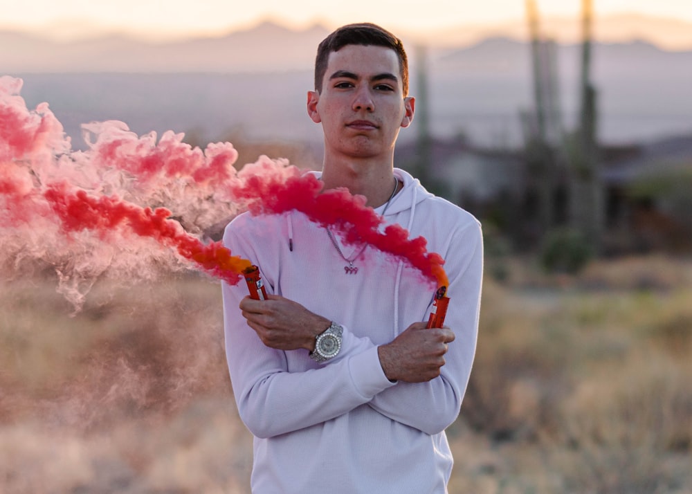 man in blue dress shirt holding red smoke