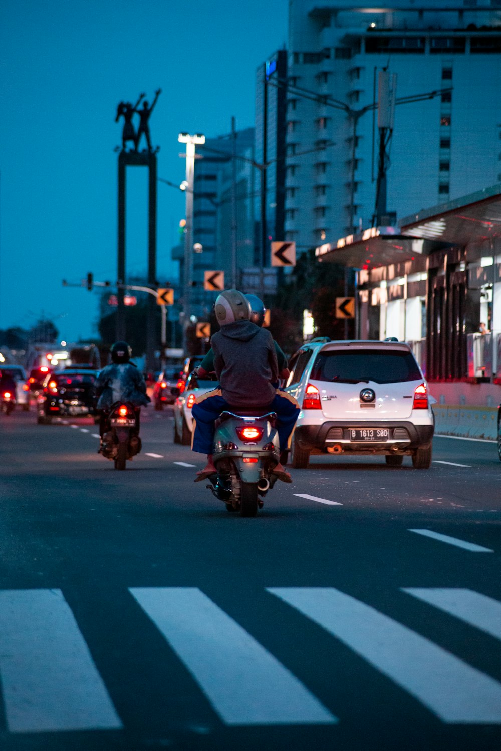 man in black jacket riding red and white motorcycle on road during daytime