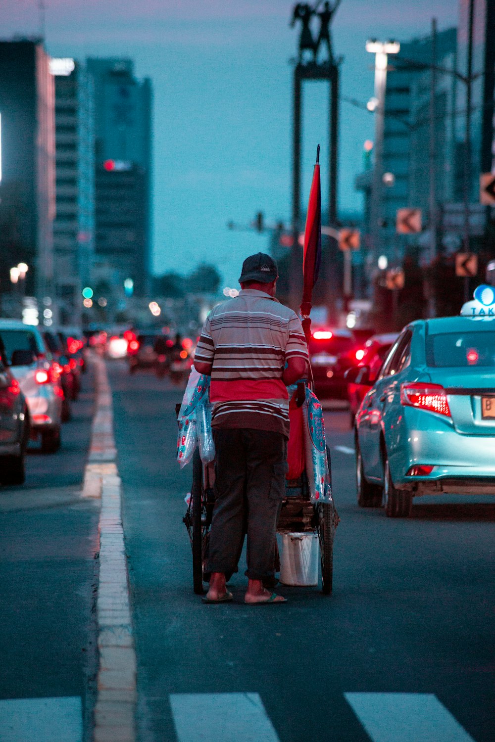 man in black jacket riding on bicycle on road during daytime