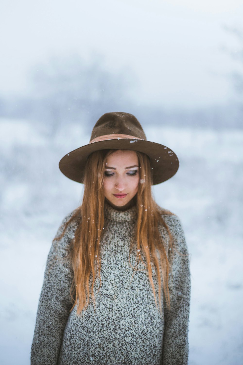 woman in black hat and gray and white sweater