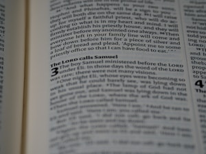 An open book displaying text in a serif font on light-colored pages. The visible text includes a heading and several lines of body text, with certain words emphasized in bold.