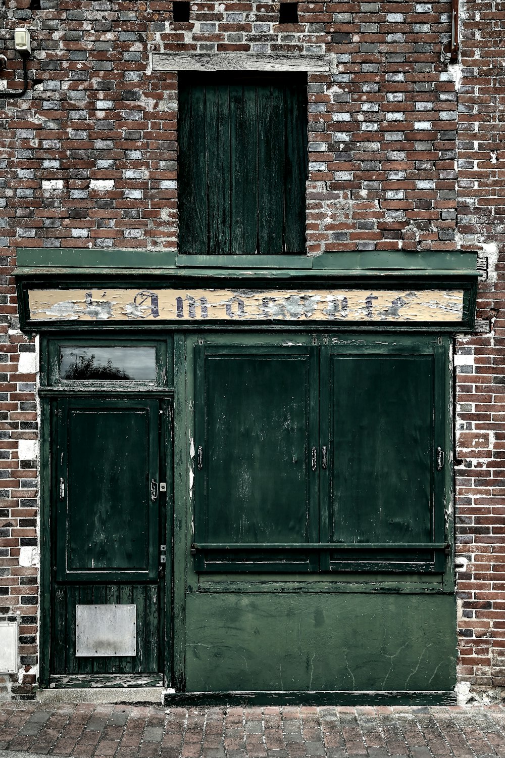 black wooden door on brown brick wall