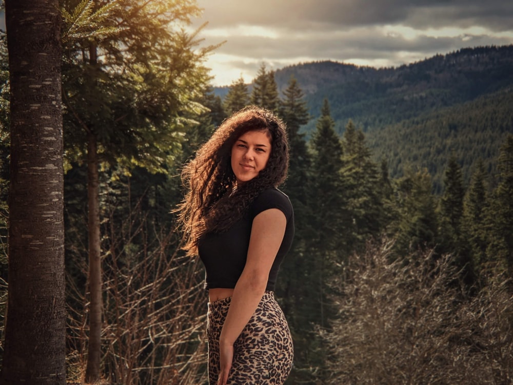 woman in black shirt standing near green tree during daytime