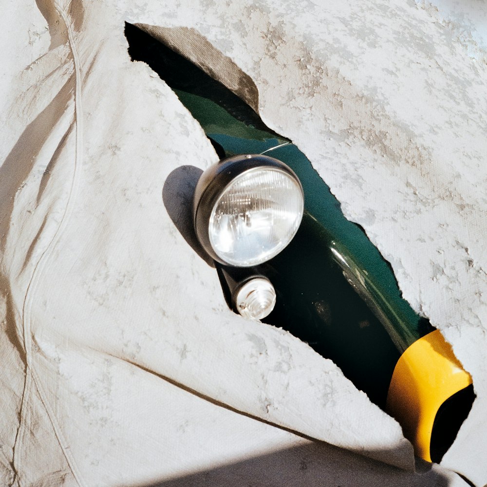 green glass bottle on white textile