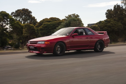 A dynamic shot of a sports car speeding along a coastal road.