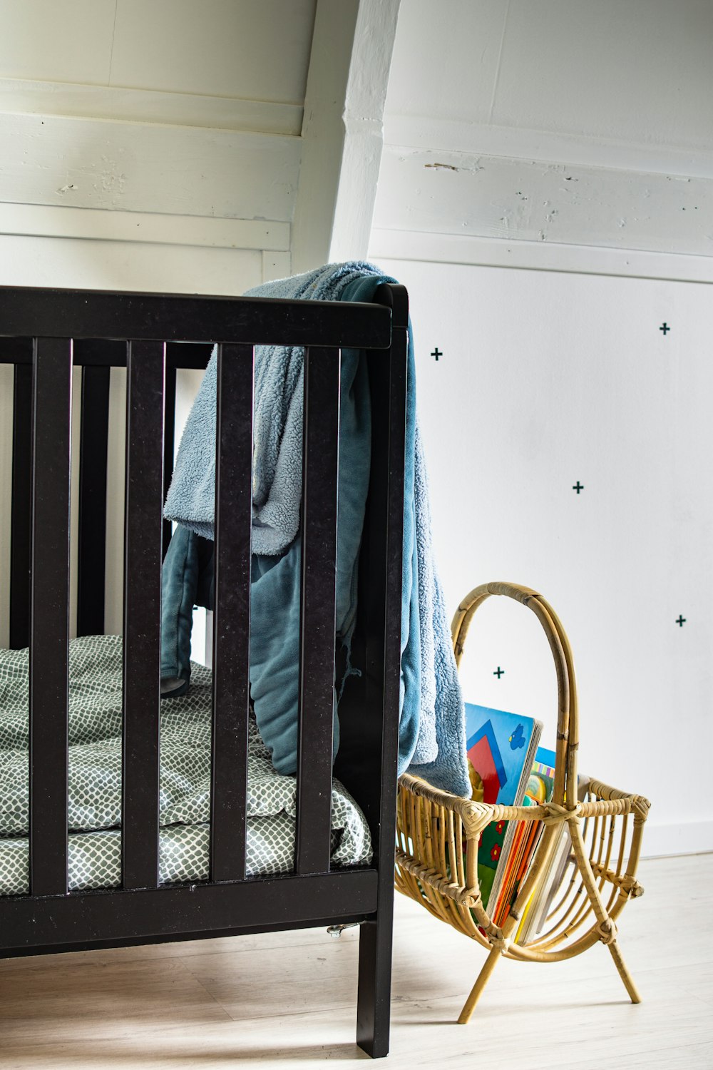 blue and gray jacket on brown wooden crib