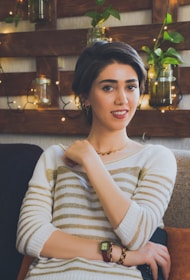 A calm person reflecting peacefully in a cozy room, surrounded by plants and soft cushions.