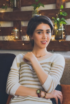 Smiling person enjoying a moment of calm in a sunlit room filled with plants.