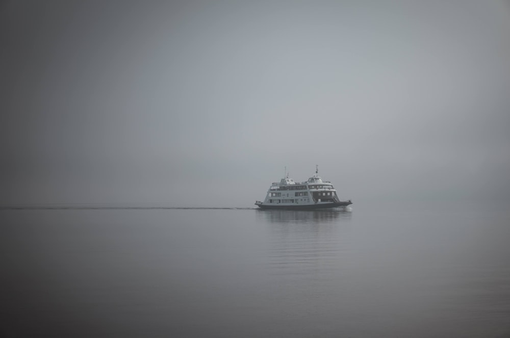 white ship on sea under white sky