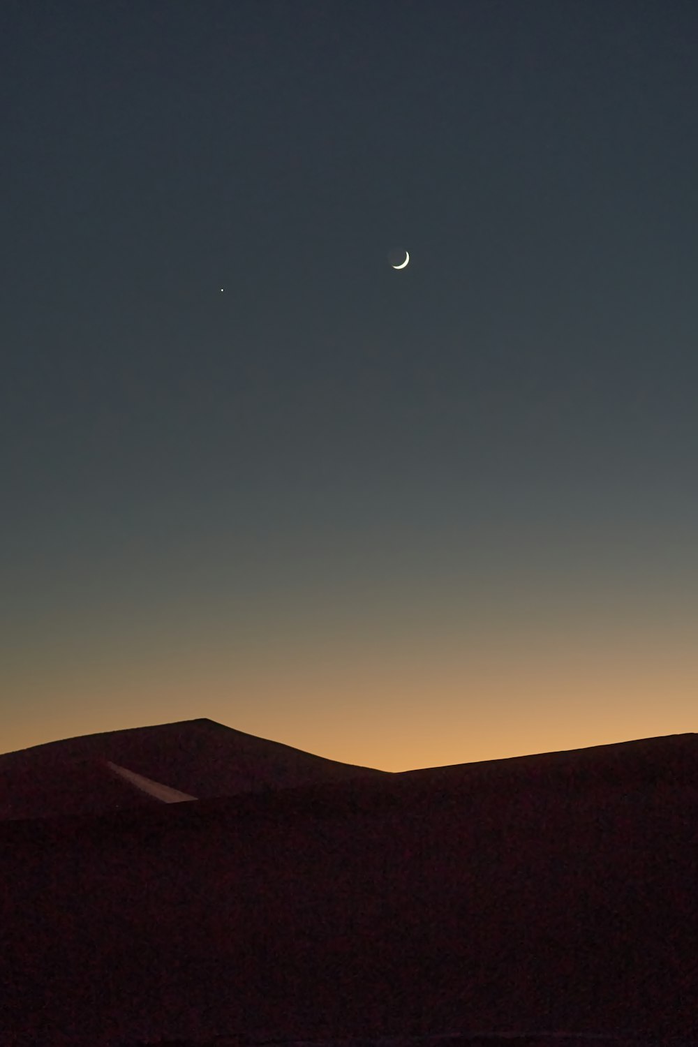 silhouette of mountain under blue sky during night time