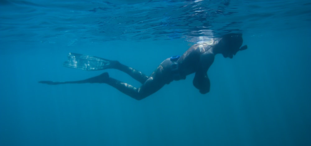 Mann in schwarzen Shorts schwimmt im Wasser