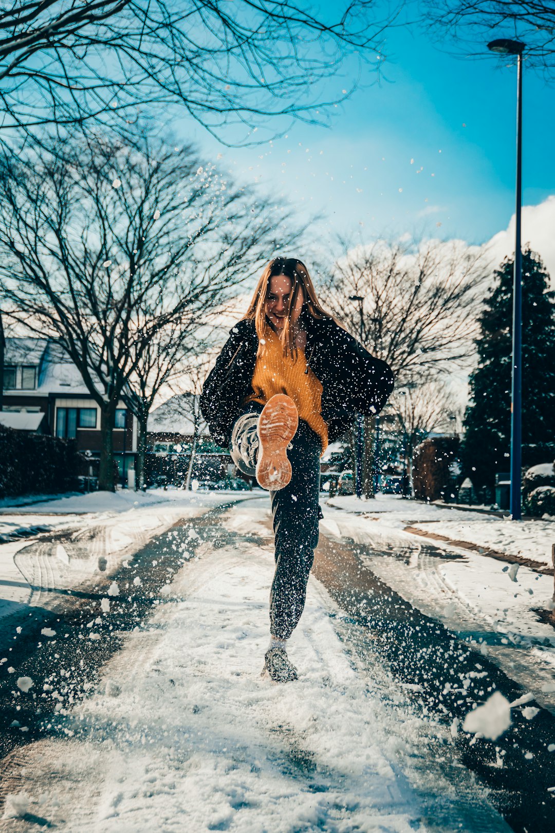 woman in black jacket standing on snow covered ground during daytime