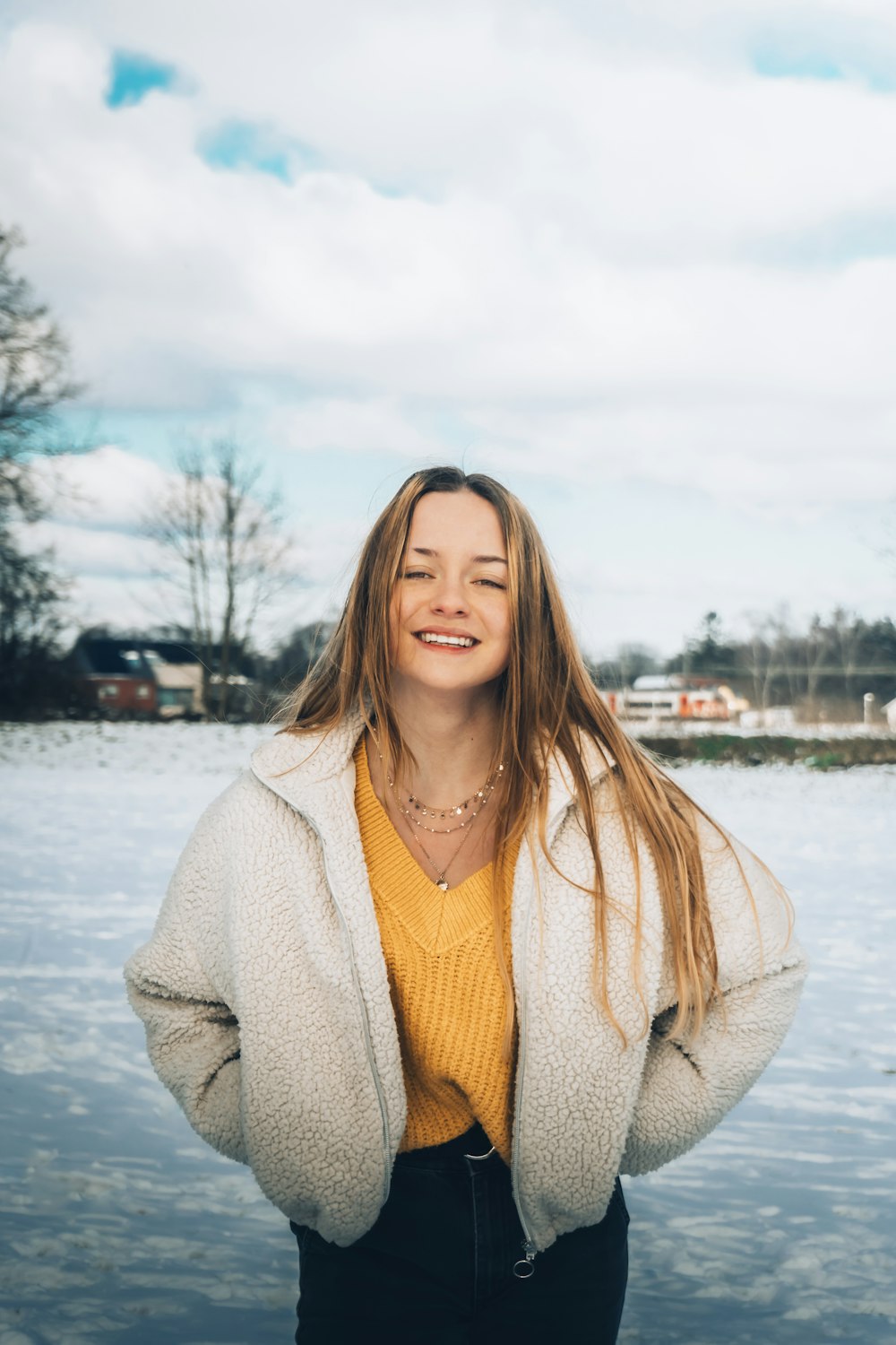 woman in beige cardigan standing near body of water during daytime