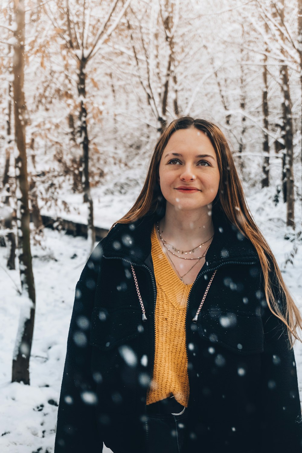 woman in black and white polka dot coat standing on snow covered ground during daytime