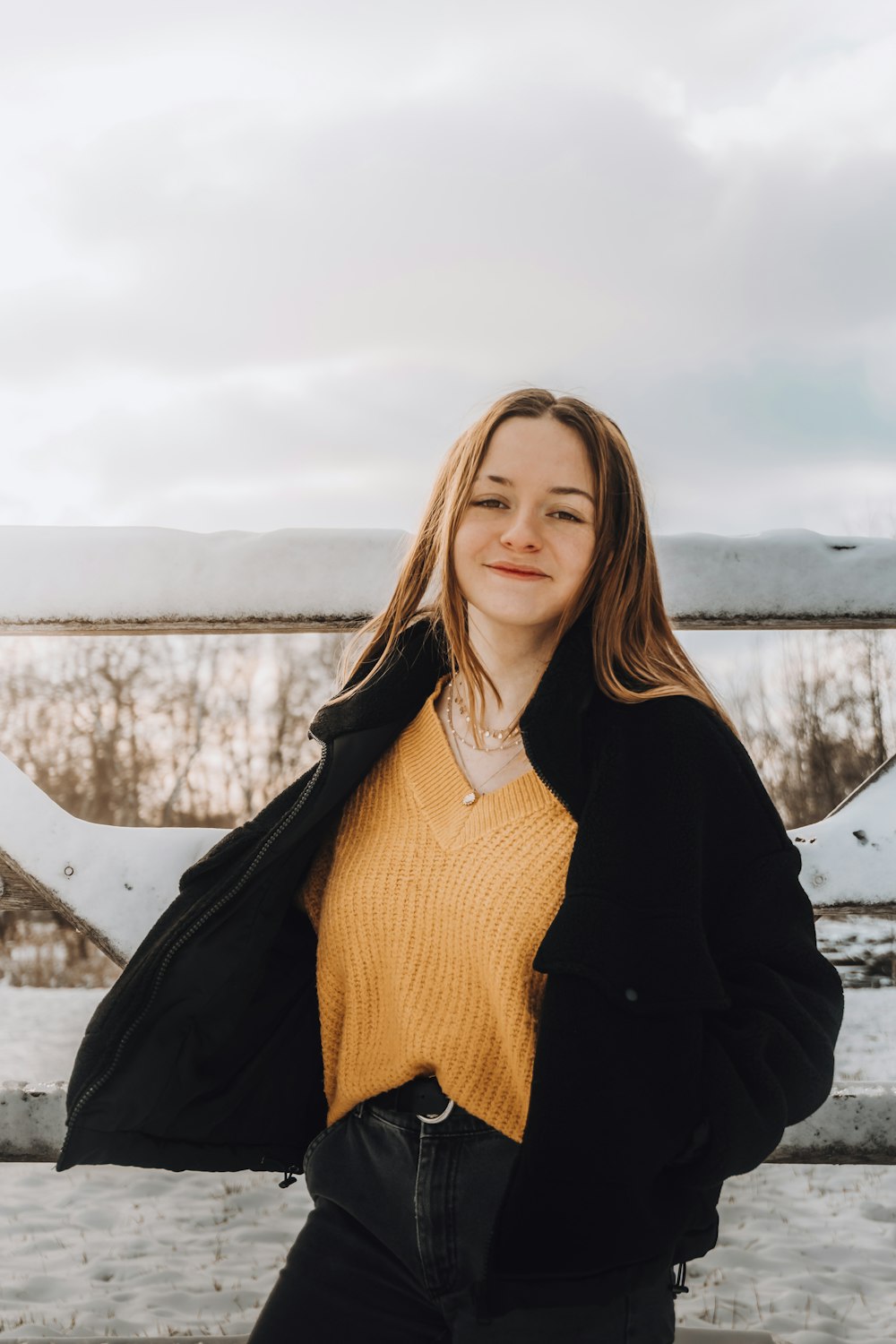 woman in black jacket standing on snow covered ground during daytime