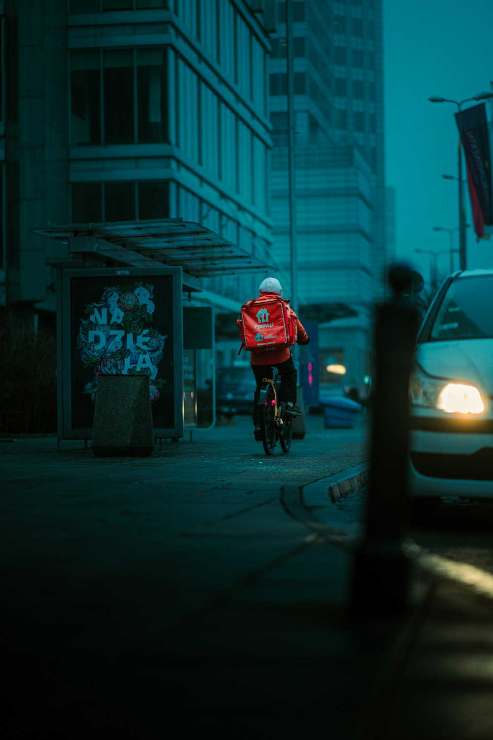 person in red jacket riding bicycle on road during daytime