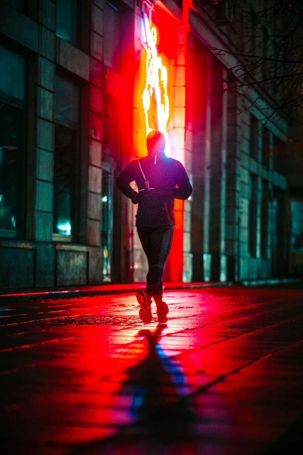man in black jacket and pants standing on red light