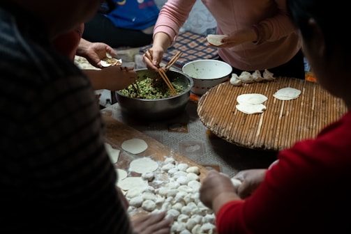 A vibrant scene of chefs skillfully preparing traditional Chinese dumplings during a CCFA culinary event.
