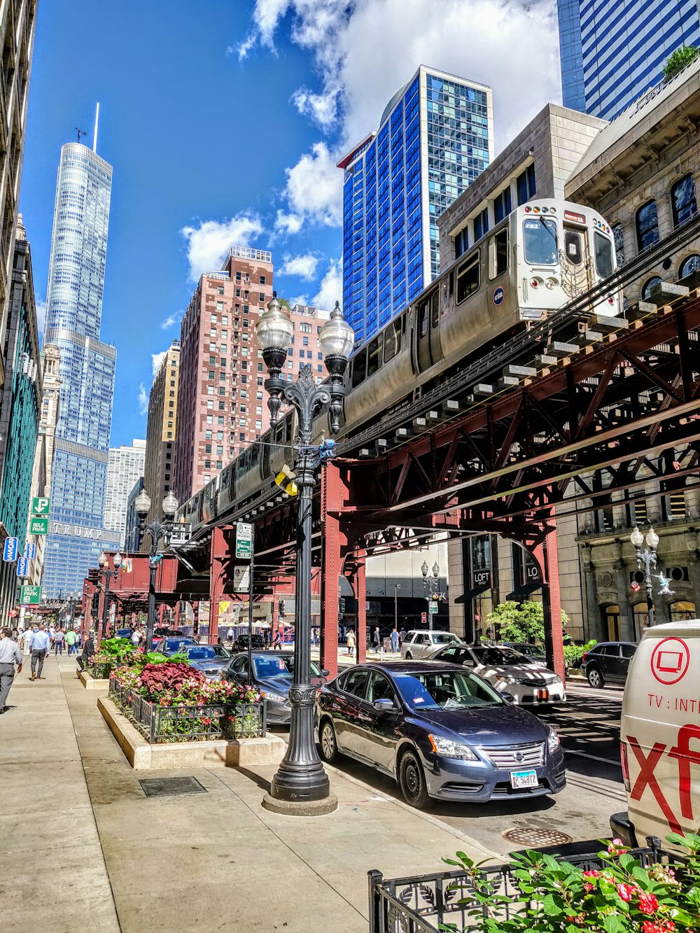 cars on road between high rise buildings during daytime