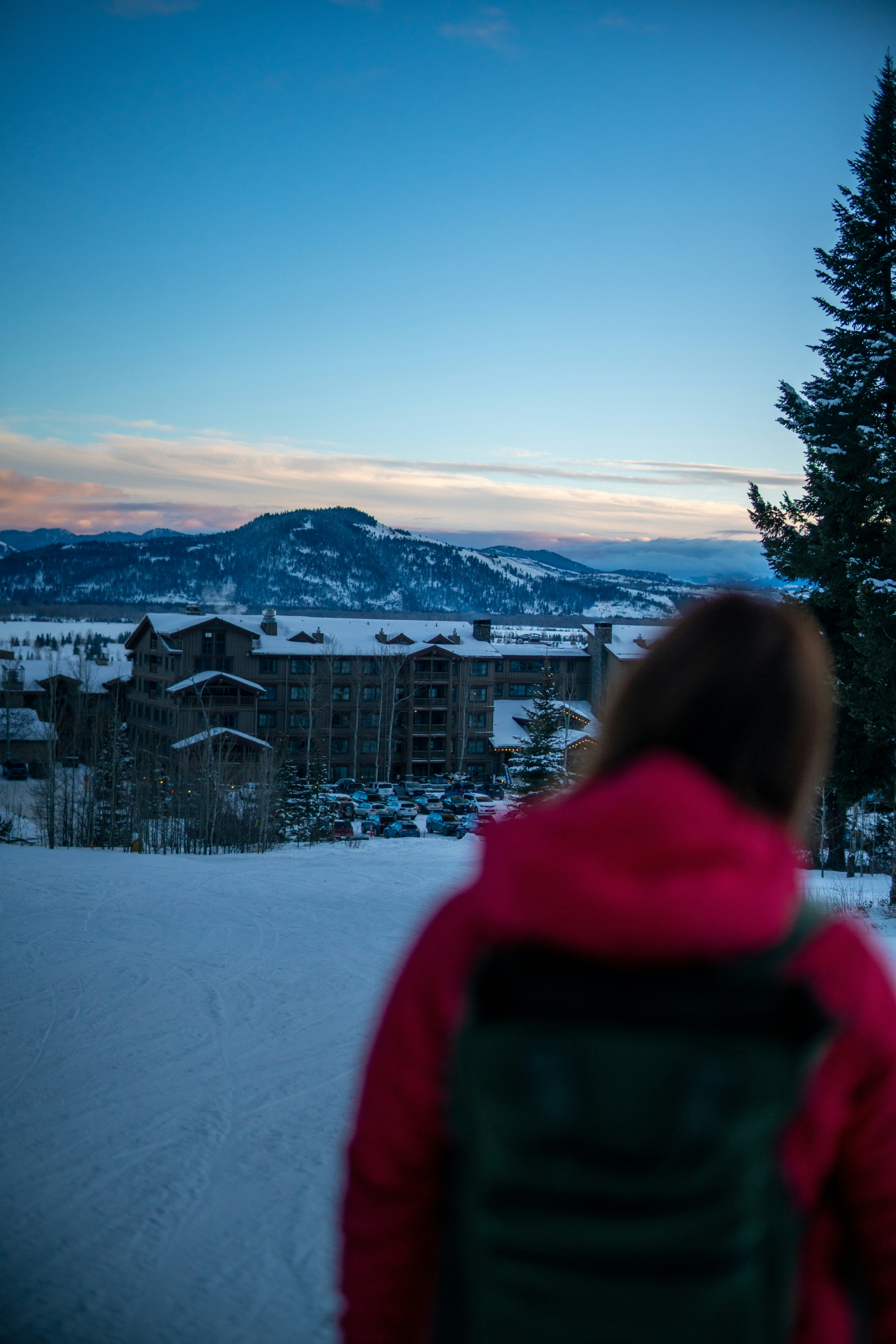 woman in red hoodie standing on snow covered ground during daytime