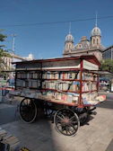 Children eagerly reading books inside the vibrant library on wheels under a clear blue sky.