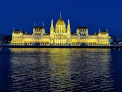 white concrete building near body of water during night time