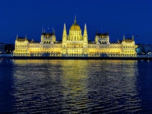 white concrete building near body of water during night time